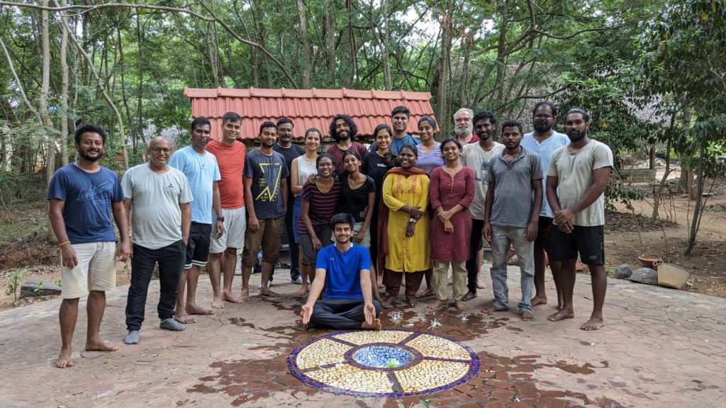 A group of people standing with trees in the background.