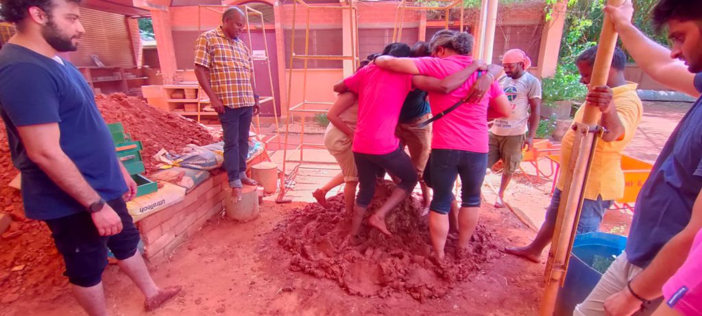 People walking on mud in a group.