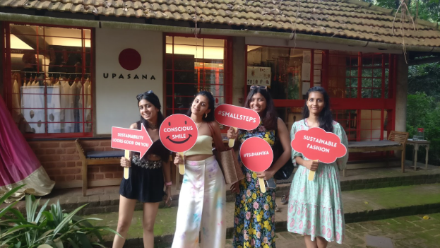 4 girls standing with banners in front of a building made of tile